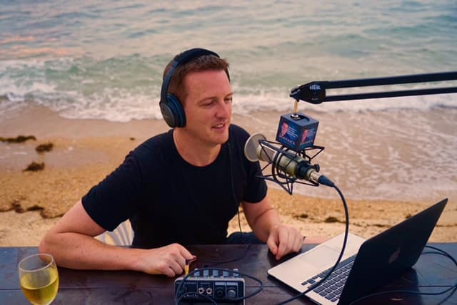 guy doing a podcast by the shore